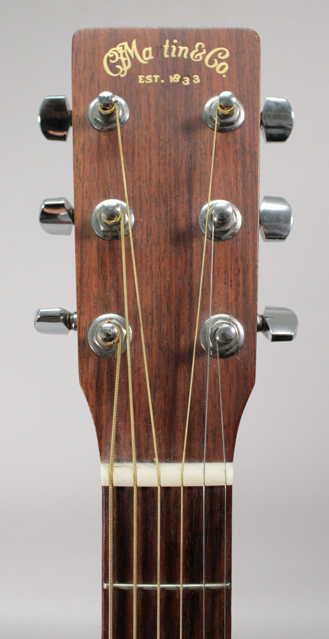Close-up of the guitar's mahogany headstock with a satin finish, showing six chrome tuners and the top of the dark fretboard.