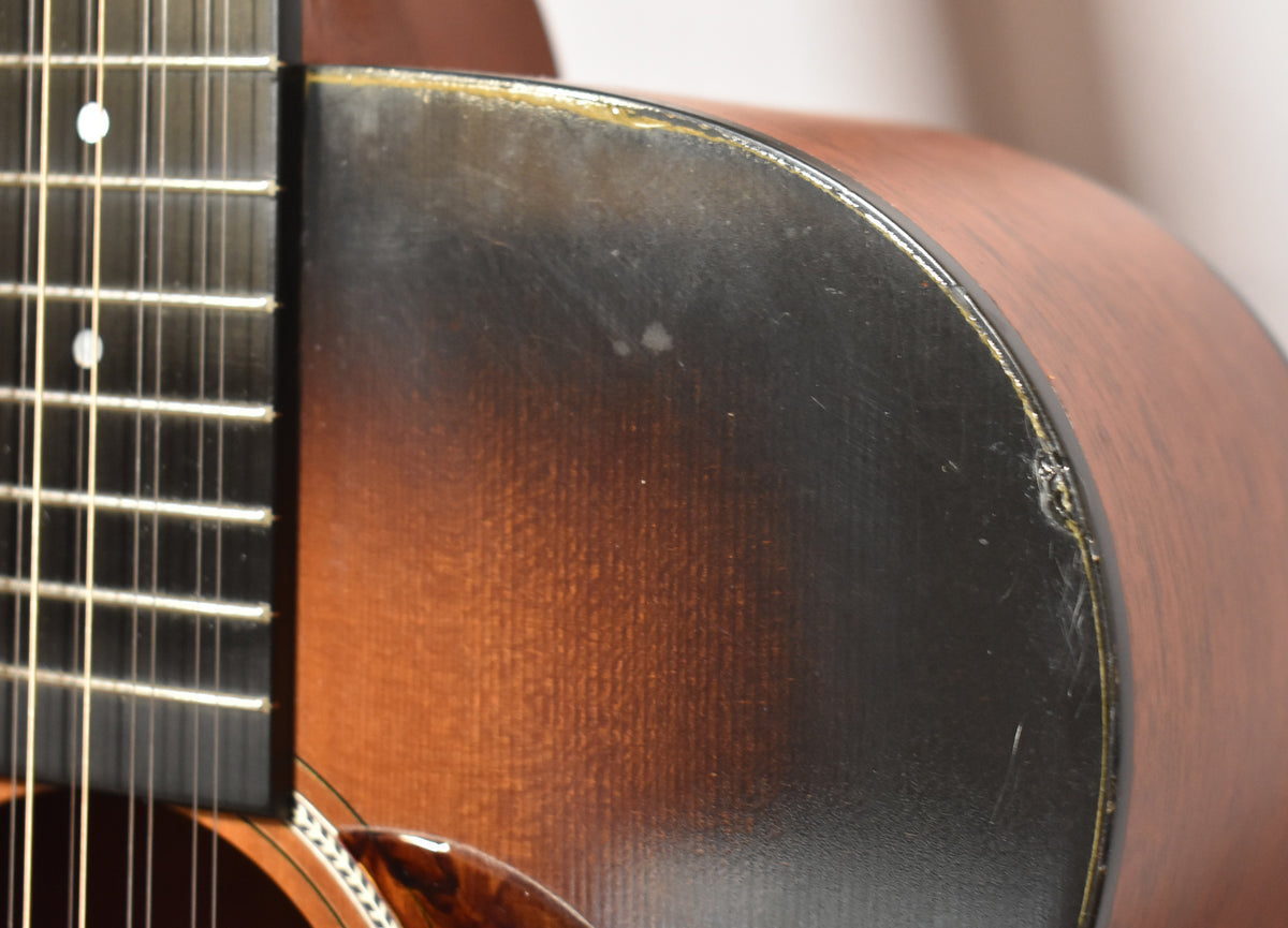 Close-up of the sunburst body and lower fretboard, showing finish wear, scratches, and a ding on the binding.
