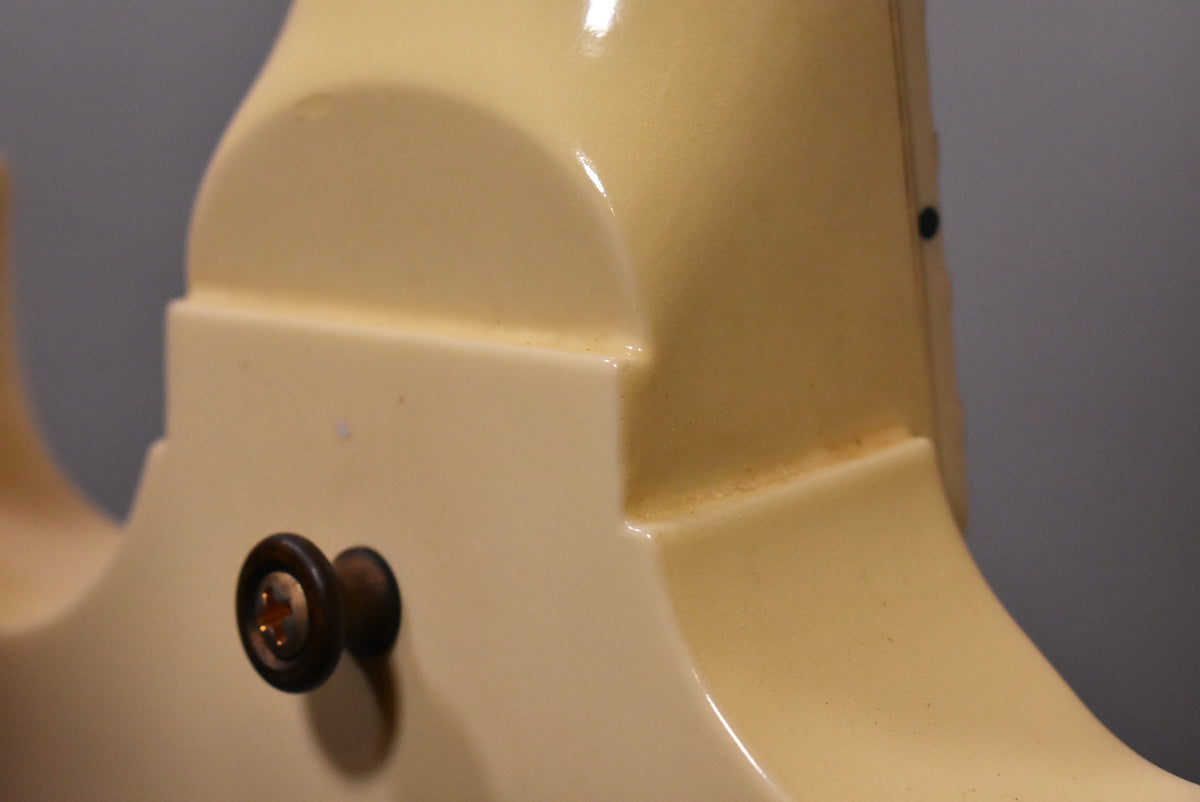 Close-up of the guitar's Alpine White body, showing the neck joint and a dark strap button with a visible screw.