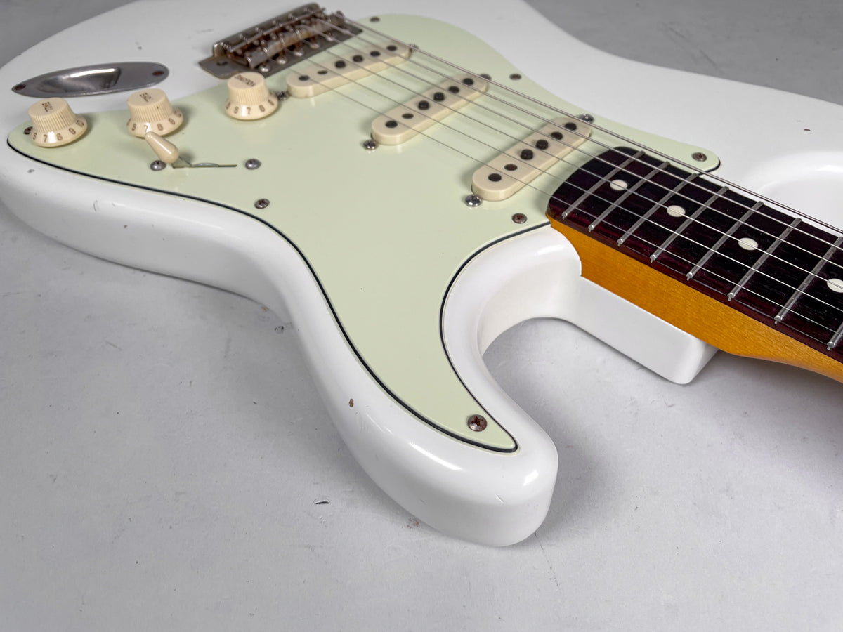 Upper body of an Olympic white Strat-style guitar, showing the relic finish, mint green pickguard, and aged white controls.