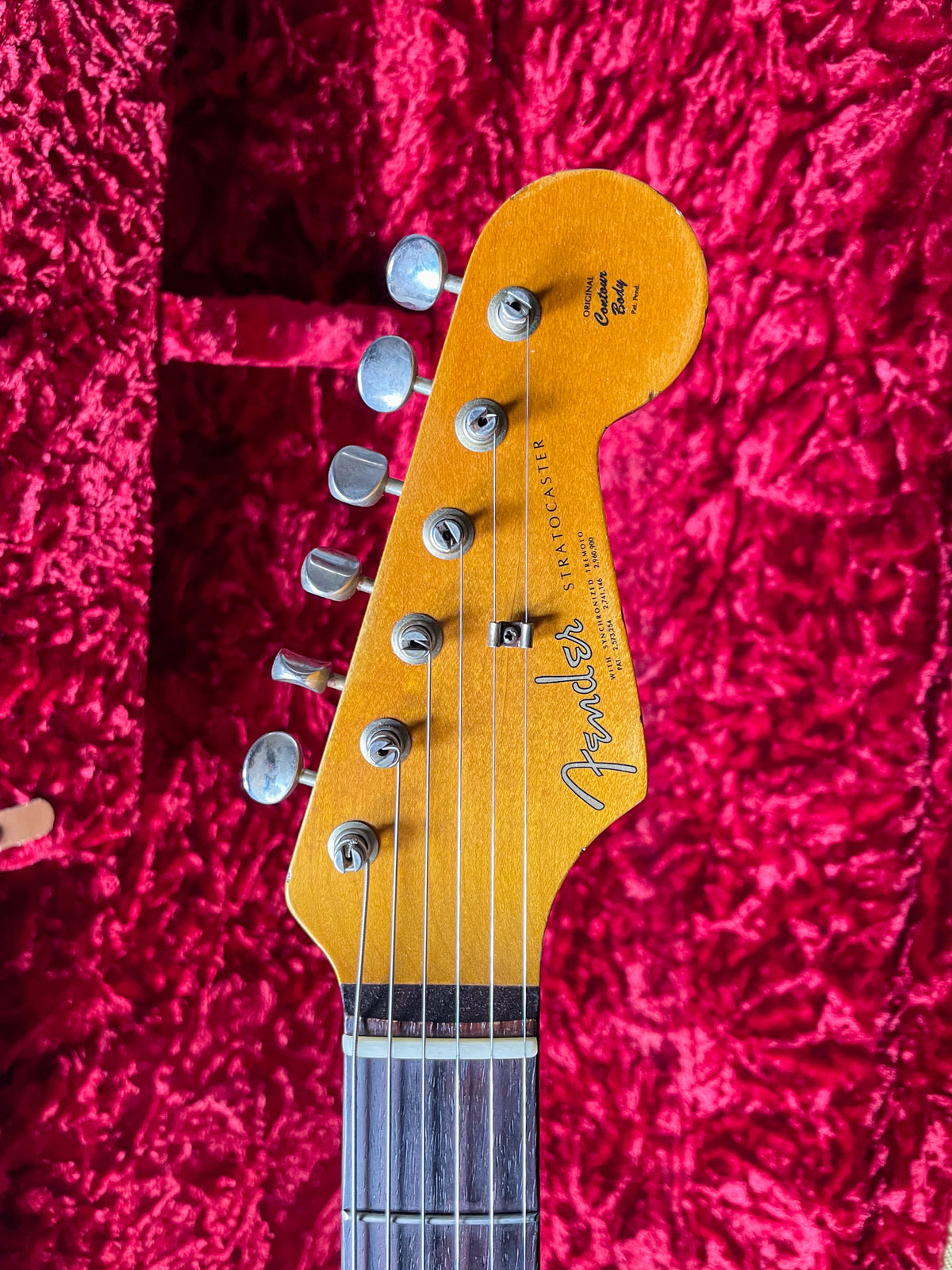 Close-up of the guitar's headstock, showing six chrome tuners, a string tree, and a vintage ambered finish with light relic wear.
