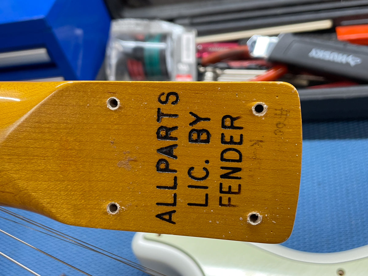 The guitar's relic'd maple neck heel, with four screw holes and "ALLPARTS LIC. BY FENDER" stamped in black.