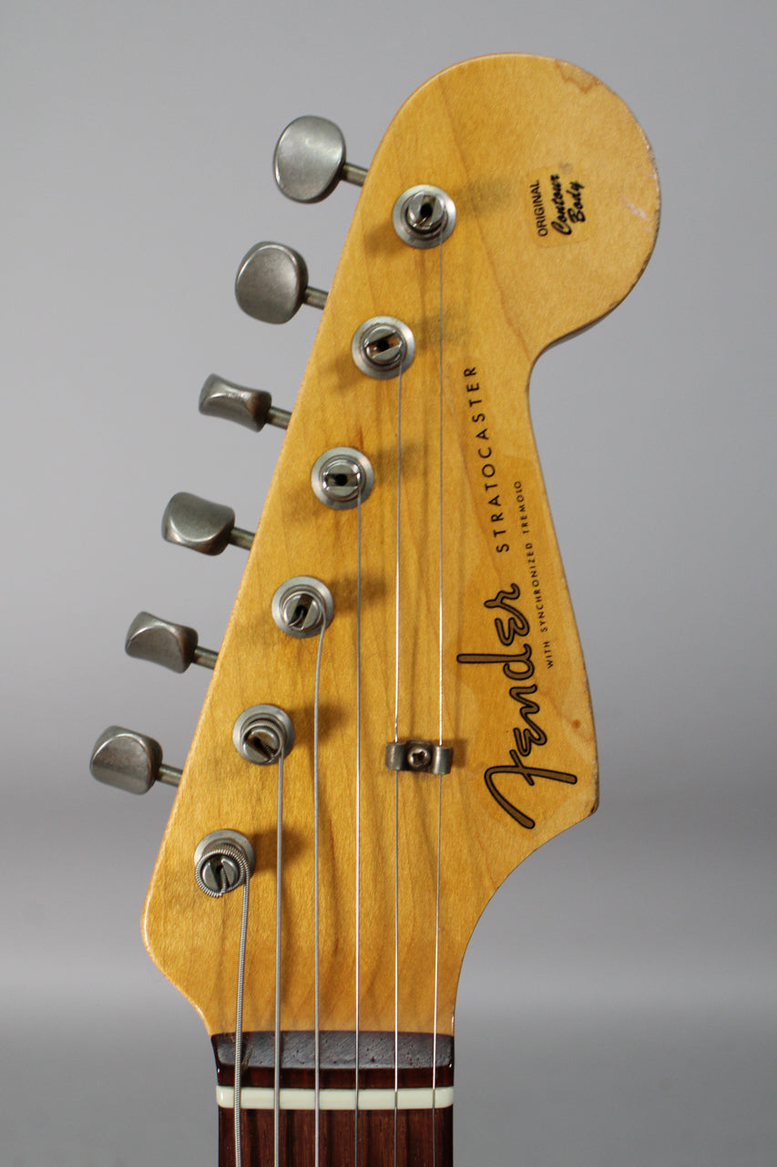 Close-up of the guitar's headstock, showing six aged nickel tuners, a string tree, and light relic wear on the natural finish.