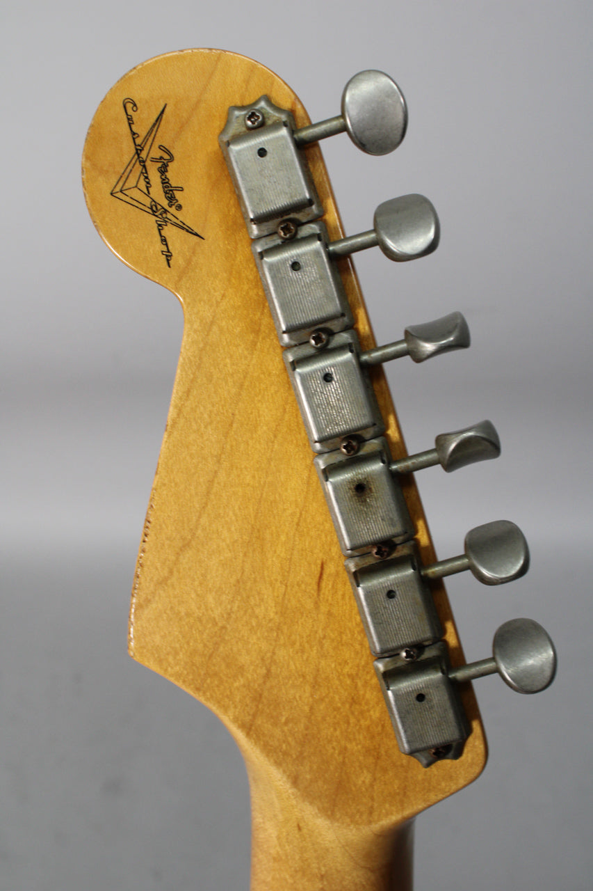 Close-up of the guitar's headstock, showing six aged nickel tuners and a worn maple neck with a dark Custom Shop logo.