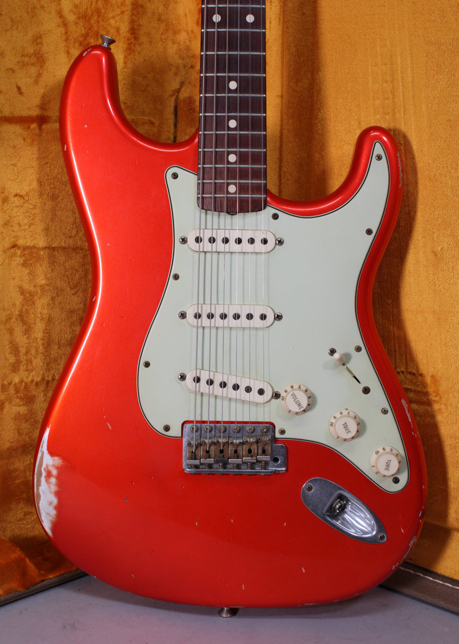 Full-frame view of the guitar's body and neck, showing a heavily relic'd metallic orange finish with a mint green pickguard.