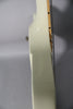 Close-up of the guitar's upper body and neck joint, showing a small scratch on the glossy alpine white finish and a chrome strap button.