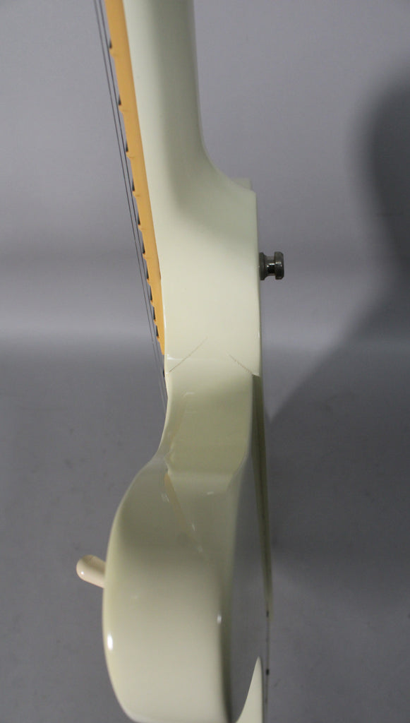 Side view of the Alpine White Firebird's neck heel and upper body, showing finish checking around the neck joint and a strap button.