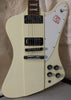 Close-up of the cream-colored guitar body, showing two chrome humbuckers, a tune-o-matic bridge, and four black control knobs.
