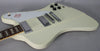 Upper body of an off-white electric guitar with a white pickguard, two chrome humbuckers, a tune-o-matic bridge, and four black control knobs.