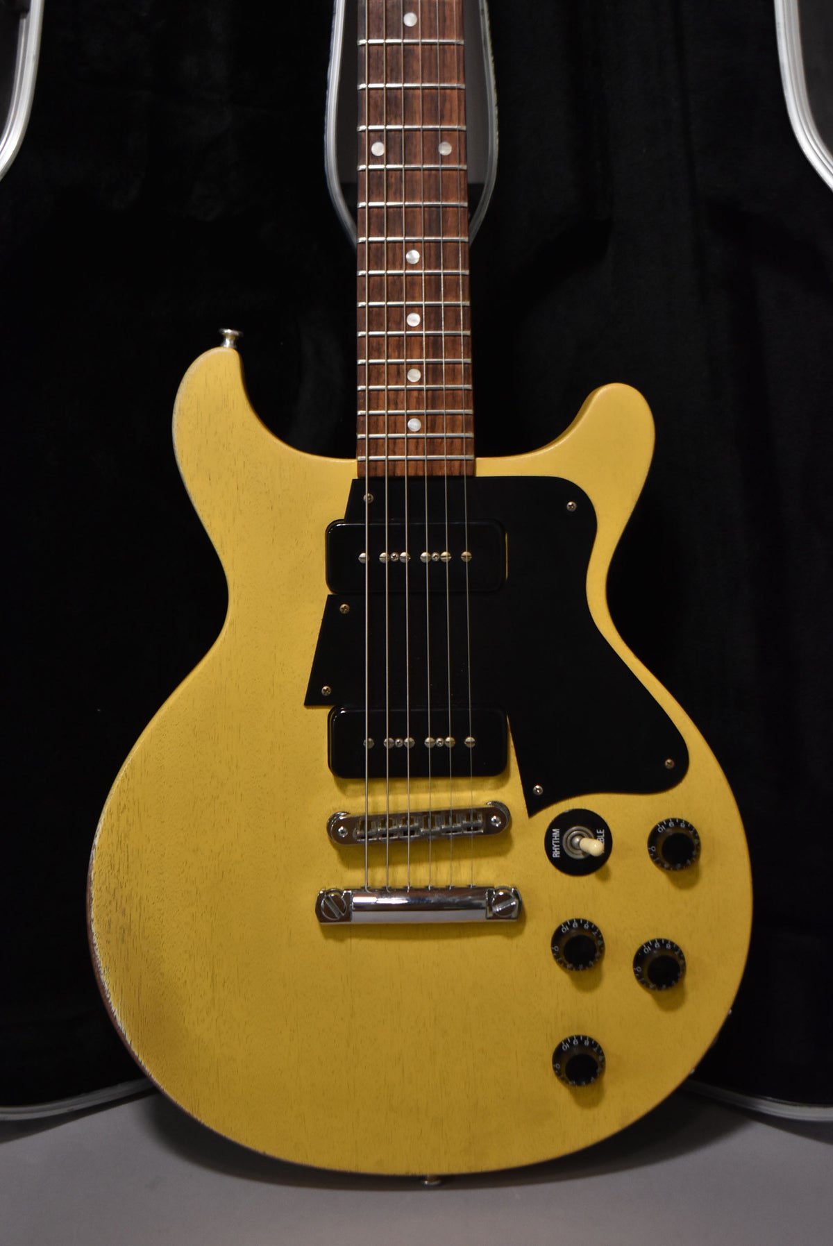 Full front view of a faded TV yellow double-cutaway electric guitar with two black P90 pickups, a black pickguard, and four black control knobs.