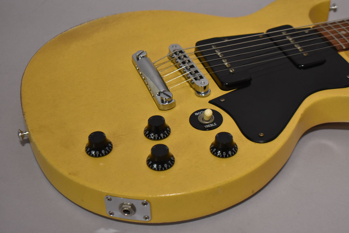 Close-up of the TV Yellow guitar body, showing the black pickguard, two P90 pickups, four black numbered knobs, and a cream toggle switch.
