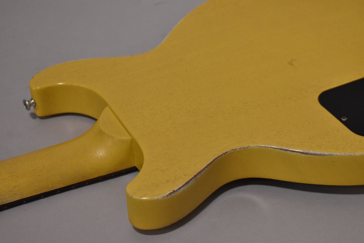 The back of the faded TV yellow guitar shows a worn finish, especially on the body edges and neck heel, with a black control plate.