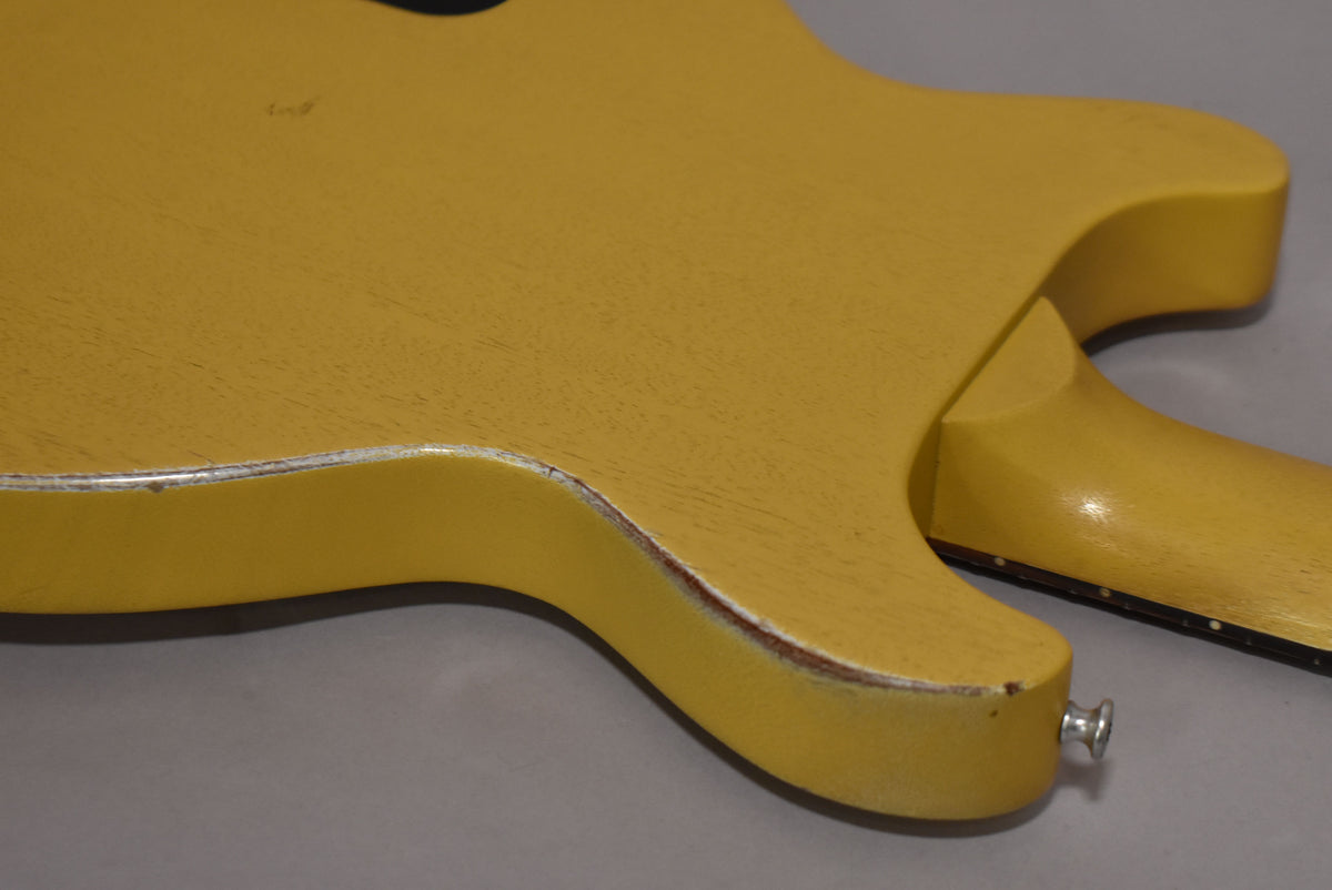 The back of the faded TV yellow guitar body, showing the neck joint, strap button, and significant wear along the lower edge.