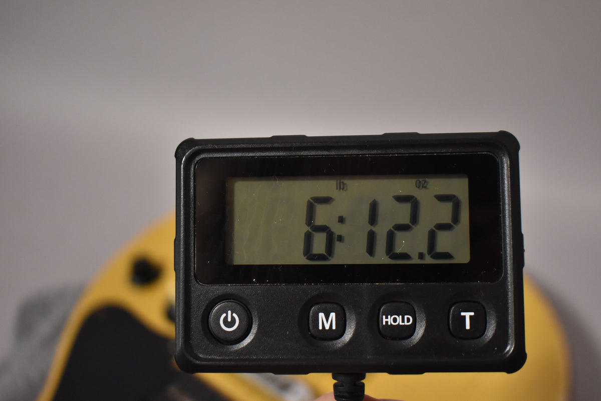 A digital scale displays "6:12.2" (6 pounds, 12.2 ounces), with a faded TV Yellow guitar body blurred in the background.