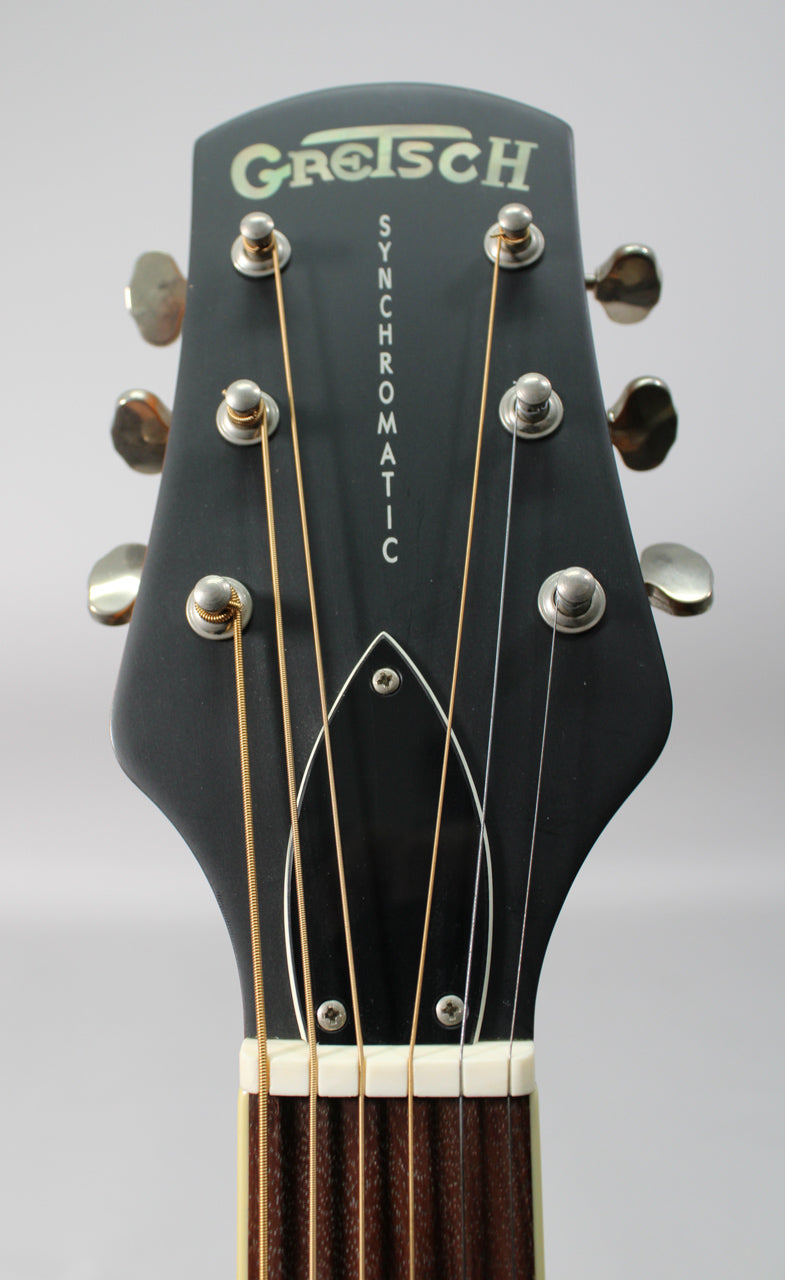 Close-up of the guitar's black matte headstock, showing six chrome tuners, a white nut, and the top of the dark fretboard.
