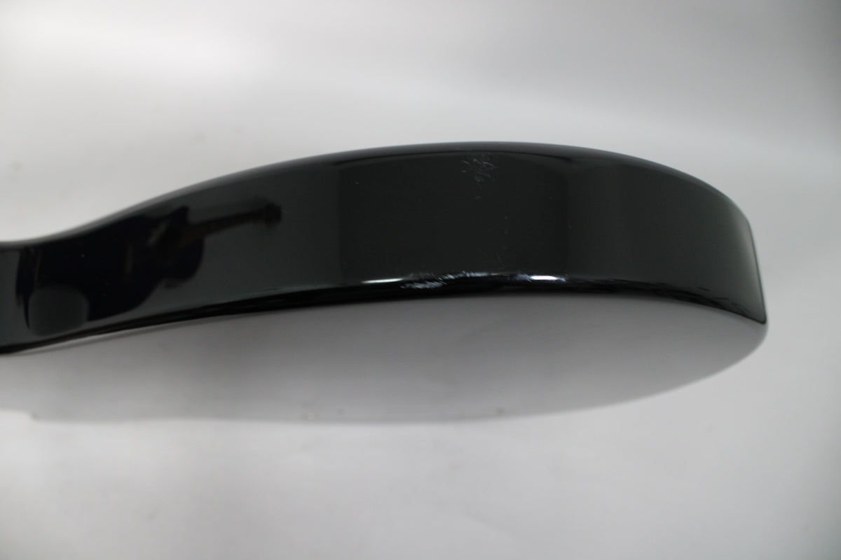 Close-up of the guitar's lower body edge, showing a glossy black finish with several small chips and scratches along the top curve.