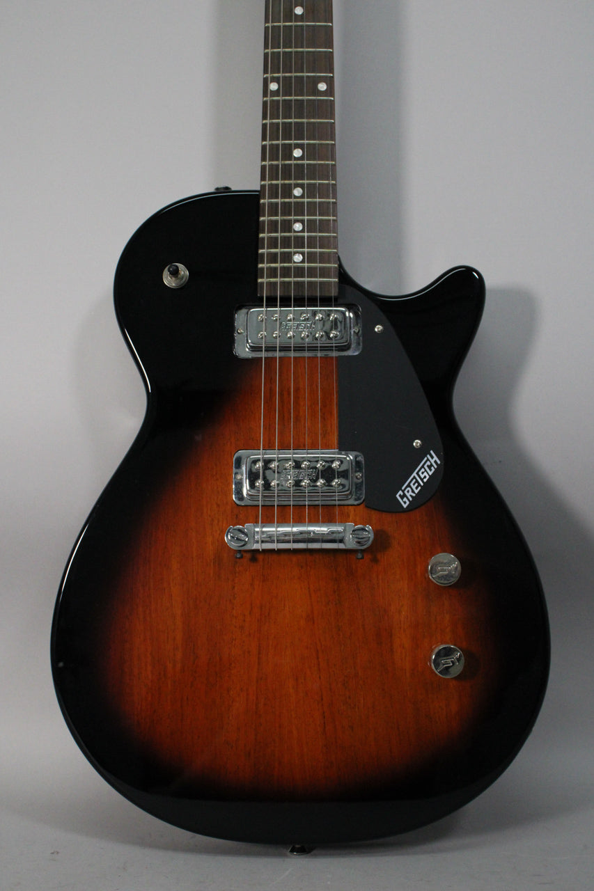 Full-front view of a tobacco sunburst electric guitar with a black pickguard, two chrome humbuckers, and two chrome control knobs.