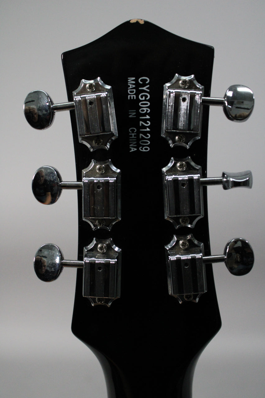 Back of a black guitar headstock with six chrome tuners, serial number CYG06121209, and "MADE IN CHINA" printed vertically.