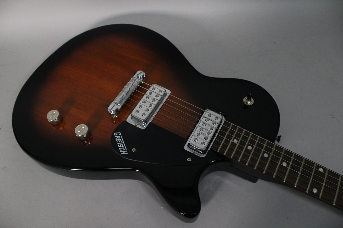 Tobacco Sunburst electric guitar, body angled from upper left, showing two chrome humbuckers, black pickguard, and two chrome knobs.