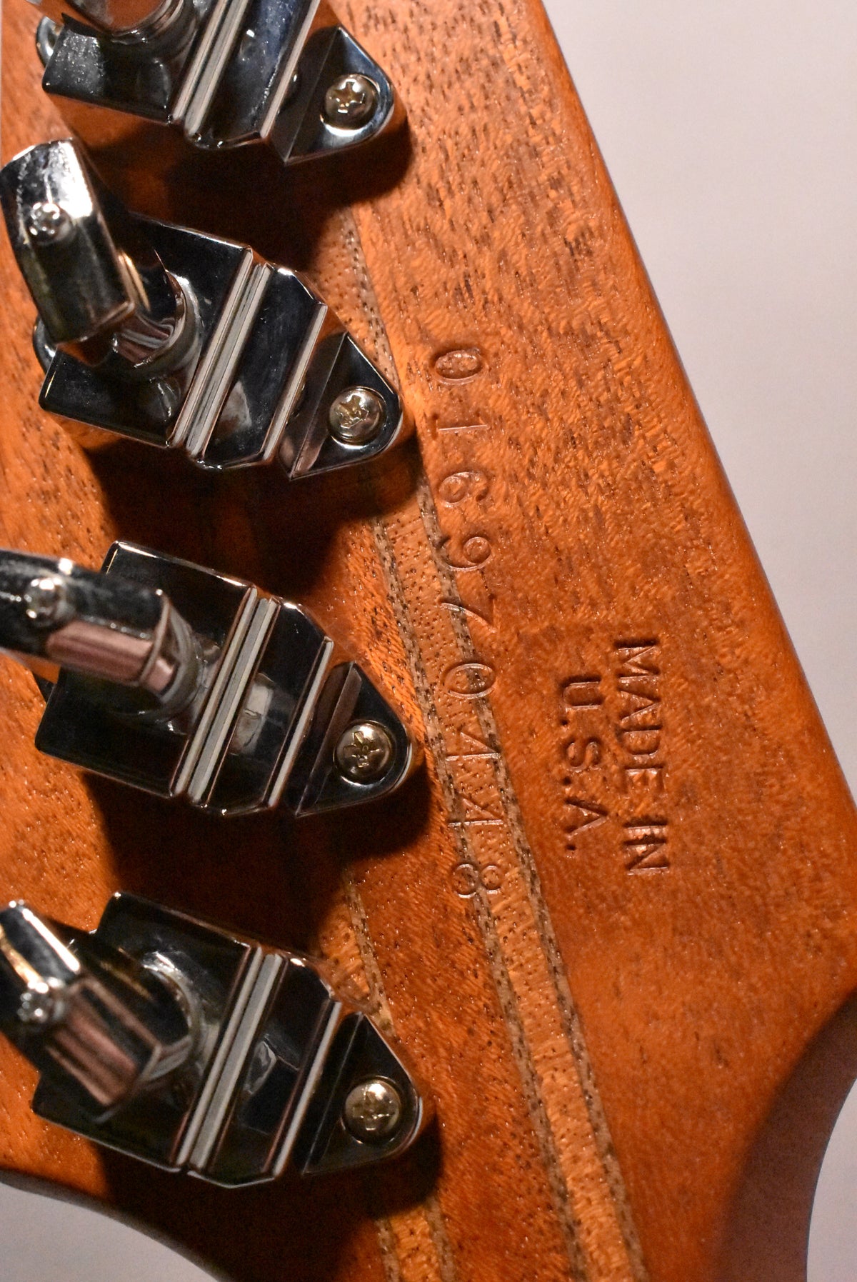 Close-up of the guitar's natural wood headstock back, showing three chrome tuners, the serial number, and "MADE IN U.S.A."