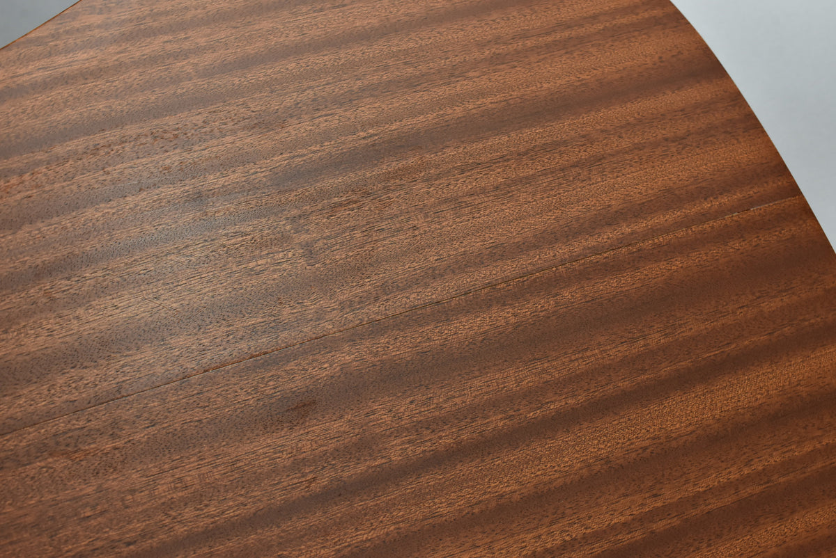 Close-up of the guitar's dark mahogany top, showing a subtle grain pattern and a faint seam running down the center.