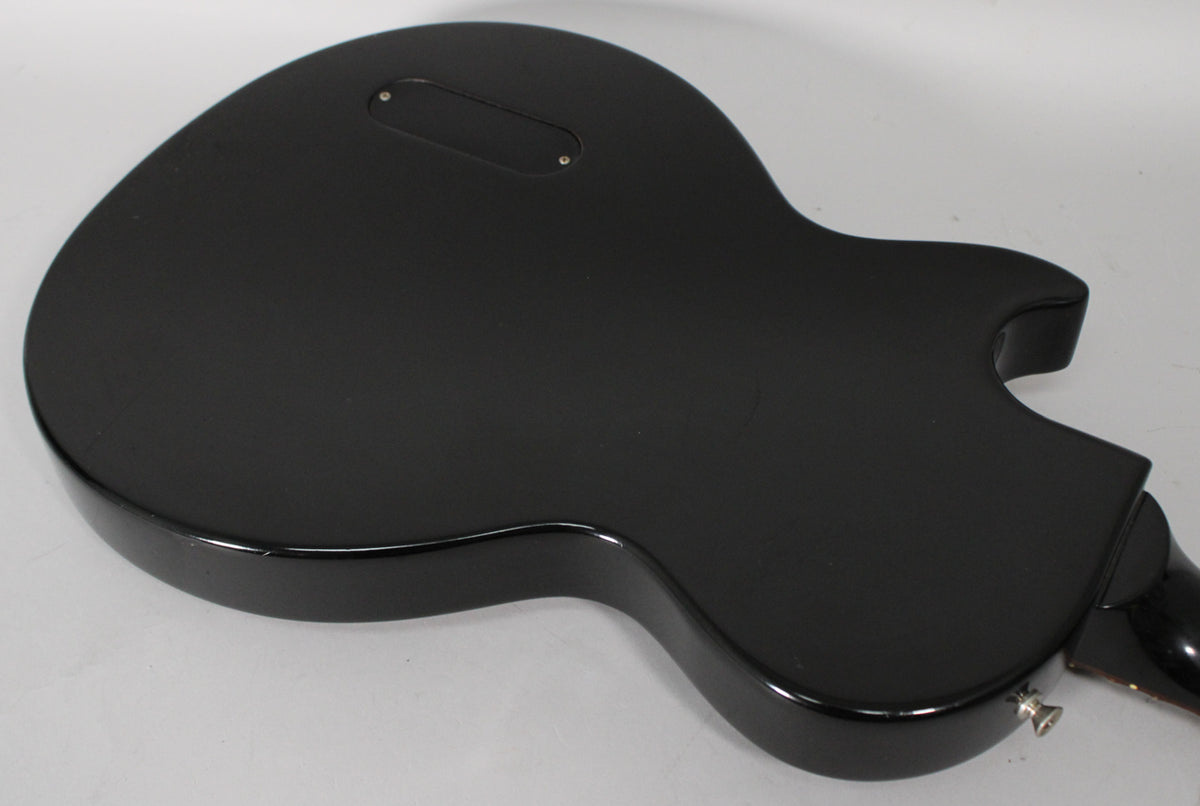 The back of the ebony Les Paul Jr. shows a matte finish with a glossy edge, a control plate, and a chrome output jack.
