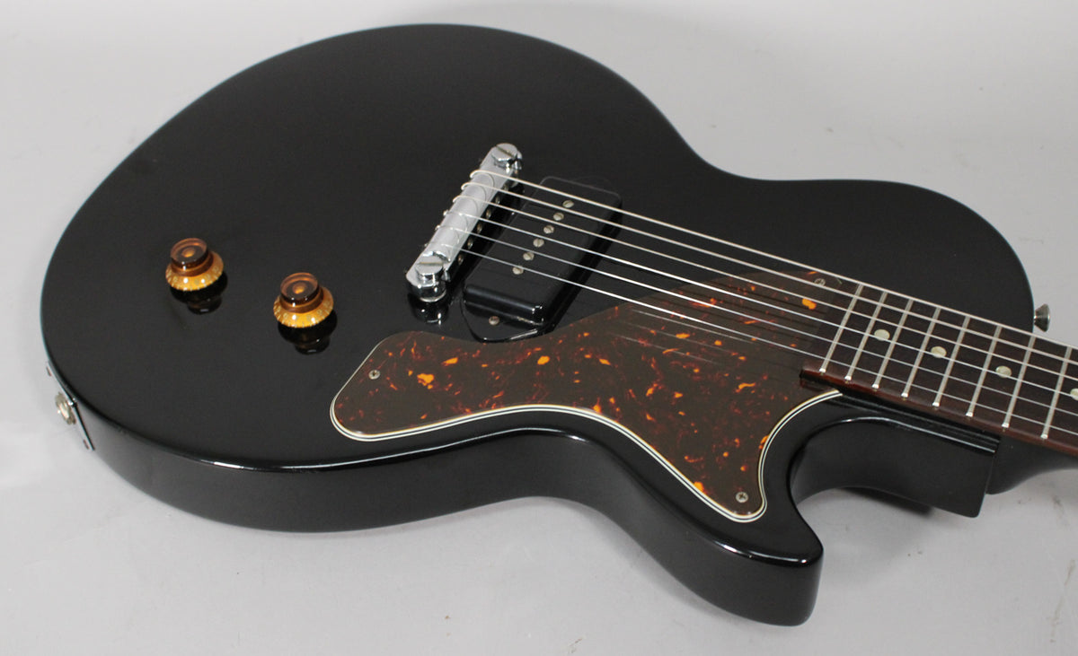 Ebony black Les Paul Jr. body, angled from the lower bout, showing two amber knobs, a single black P90 pickup, and a tortoiseshell pickguard.