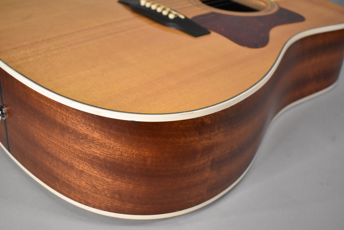 Close-up of the lower bout, showing the natural finish spruce top, mahogany sides, and a small ding on the binding.