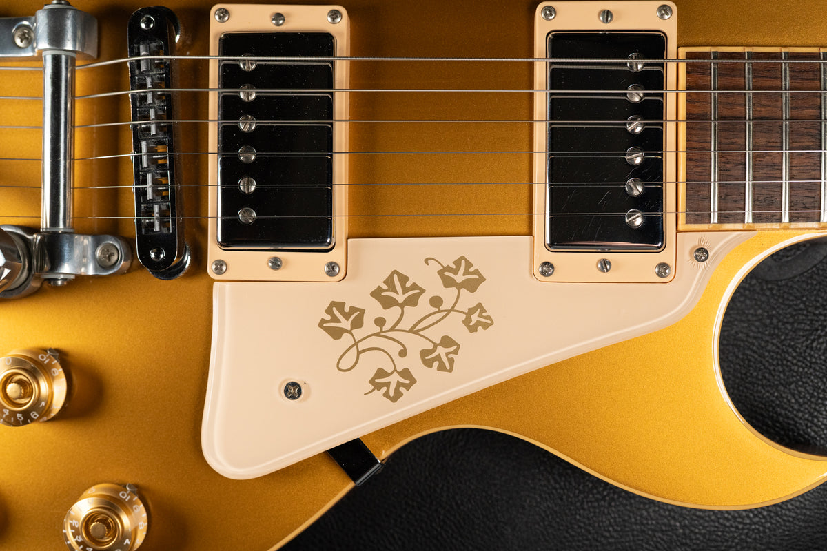 Close-up of the goldtop body, showing the cream pickguard with a gold vine inlay, two humbuckers, and gold control knobs.
