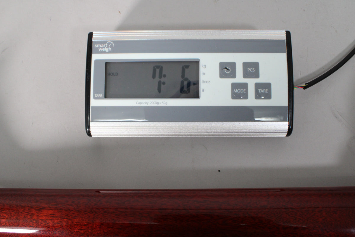 A digital scale displays "7.6" lbs, with a dark rootbeer-finished guitar body visible below.