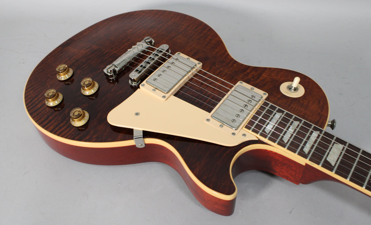 Rootbeer flame top guitar, angled from the lower bout, showing cream pickguard, pickup rings, and aged gold top hat knobs.