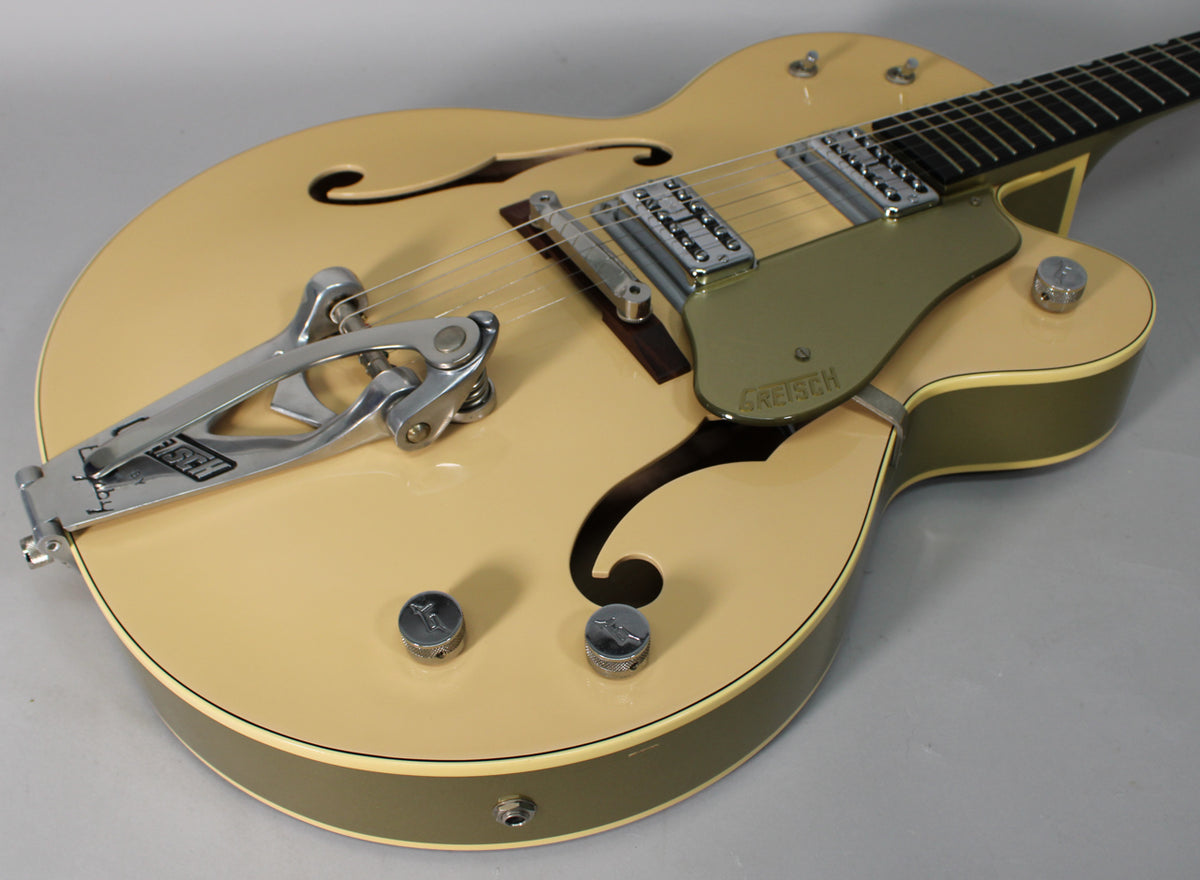 Upper body of a tan hollow-body guitar with a Bigsby vibrato, two chrome pickups, and a green pickguard.