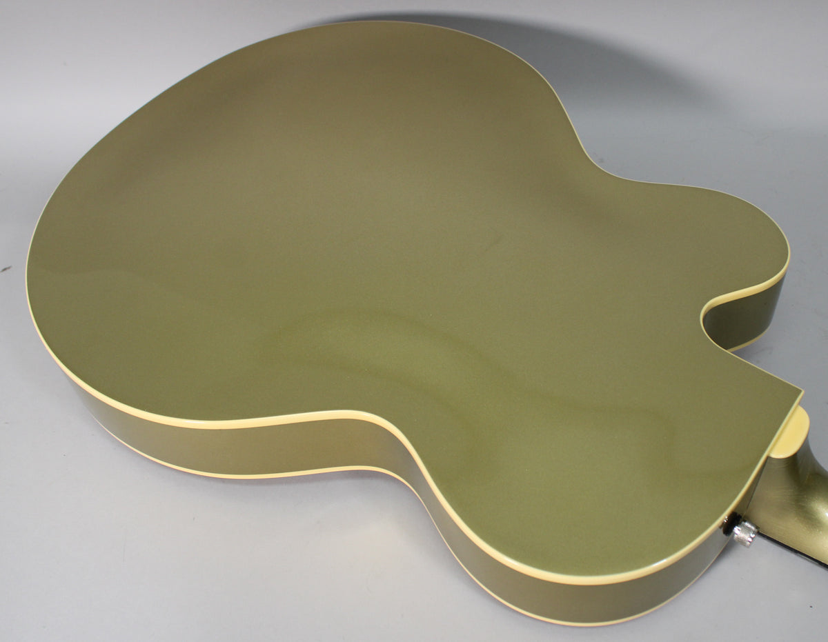The back of the hollow-body guitar, finished in metallic olive green with cream binding, is angled from the upper left.
