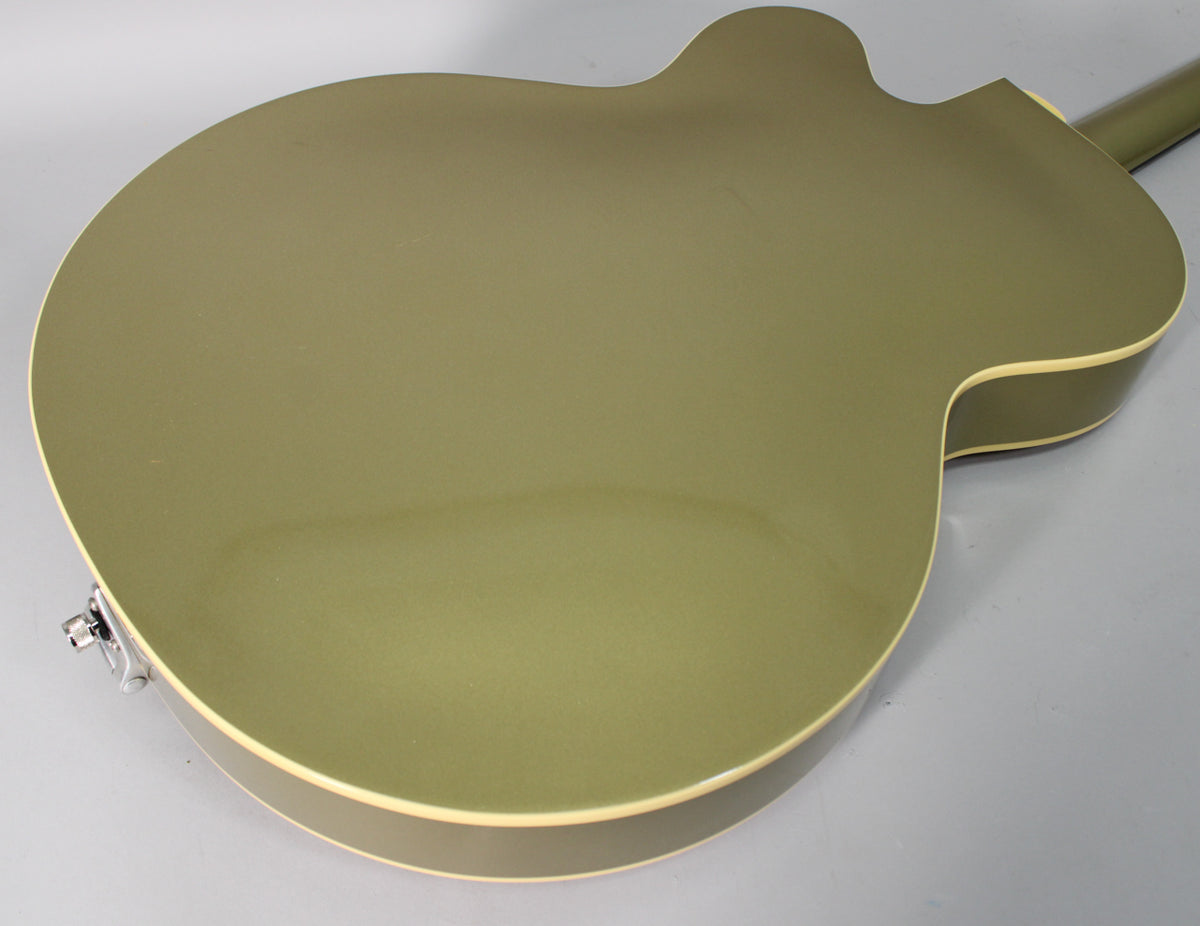The back of the tan hollow-body electric guitar, showing its glossy finish, cream binding, and a chrome strap button.