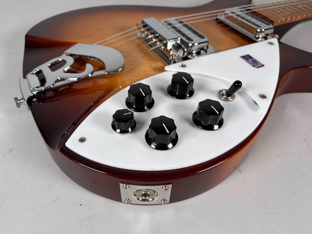 Close-up of the Montezuma Brown body, showing the white pickguard with five black knobs, a toggle switch, and chrome hardware.