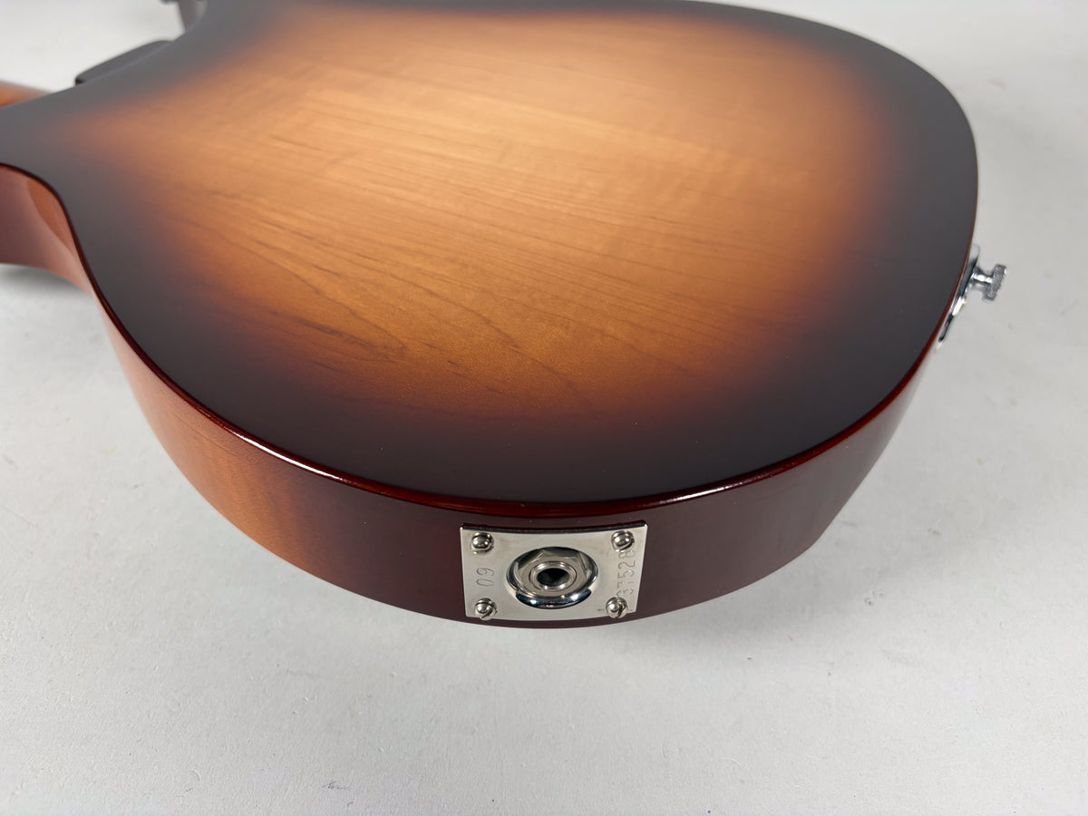 The guitar's Montezuma Brown sunburst back, with a chrome output jack plate and strap button, shows light surface wear.