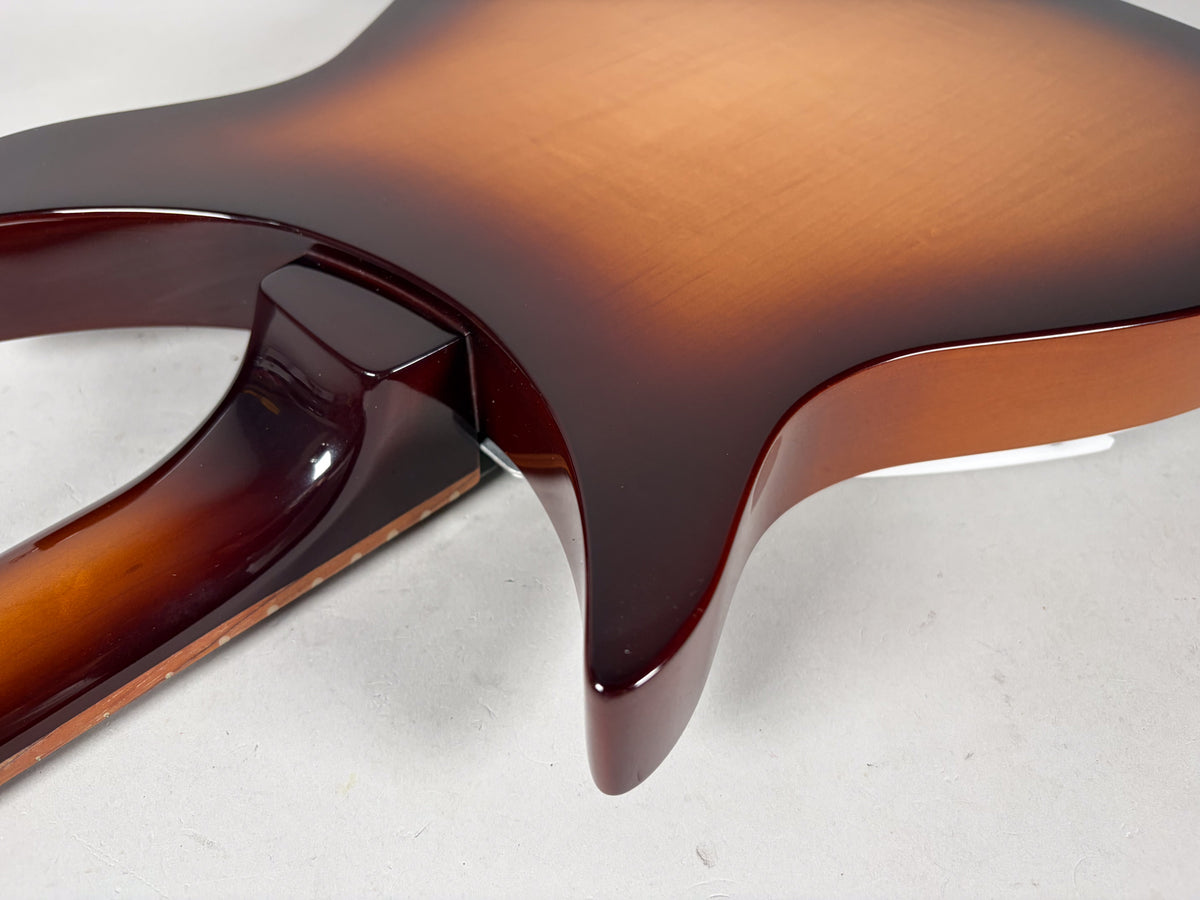 Close-up of the guitar's glossy Montezuma Brown sunburst body and neck joint, showing the dark brown neck heel and lower horn.