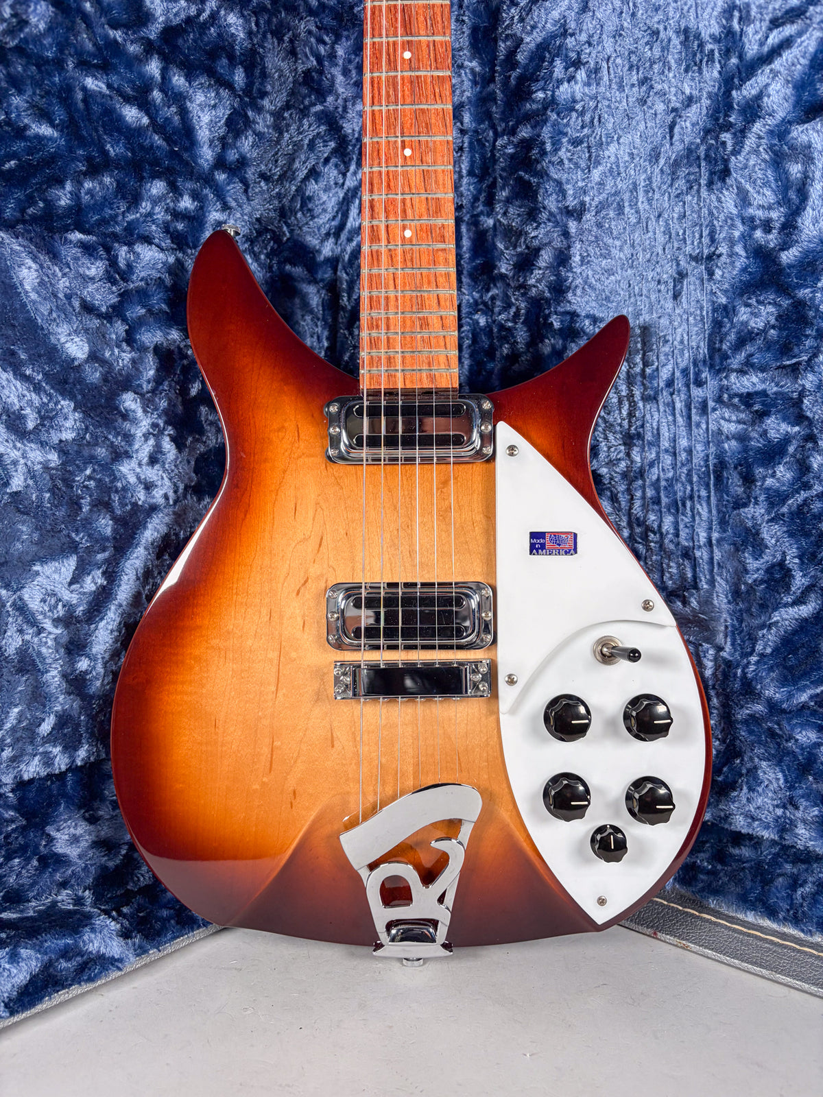 The Montezuma Brown sunburst electric guitar is angled, showing its body, three chrome pickups, white pickguard, and five black control knobs.