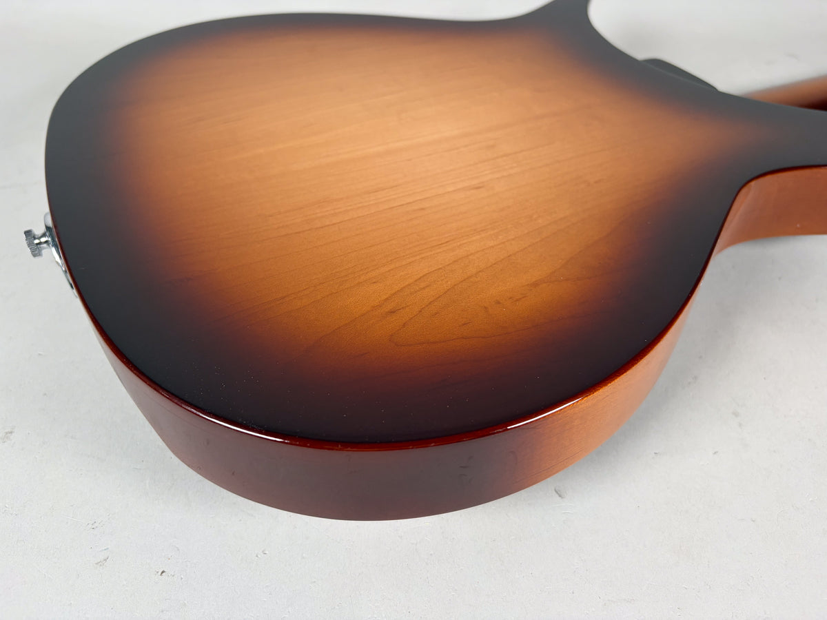 The guitar's back shows a glossy Montezuma Brown sunburst finish, fading from dark brown edges to a lighter brown center.