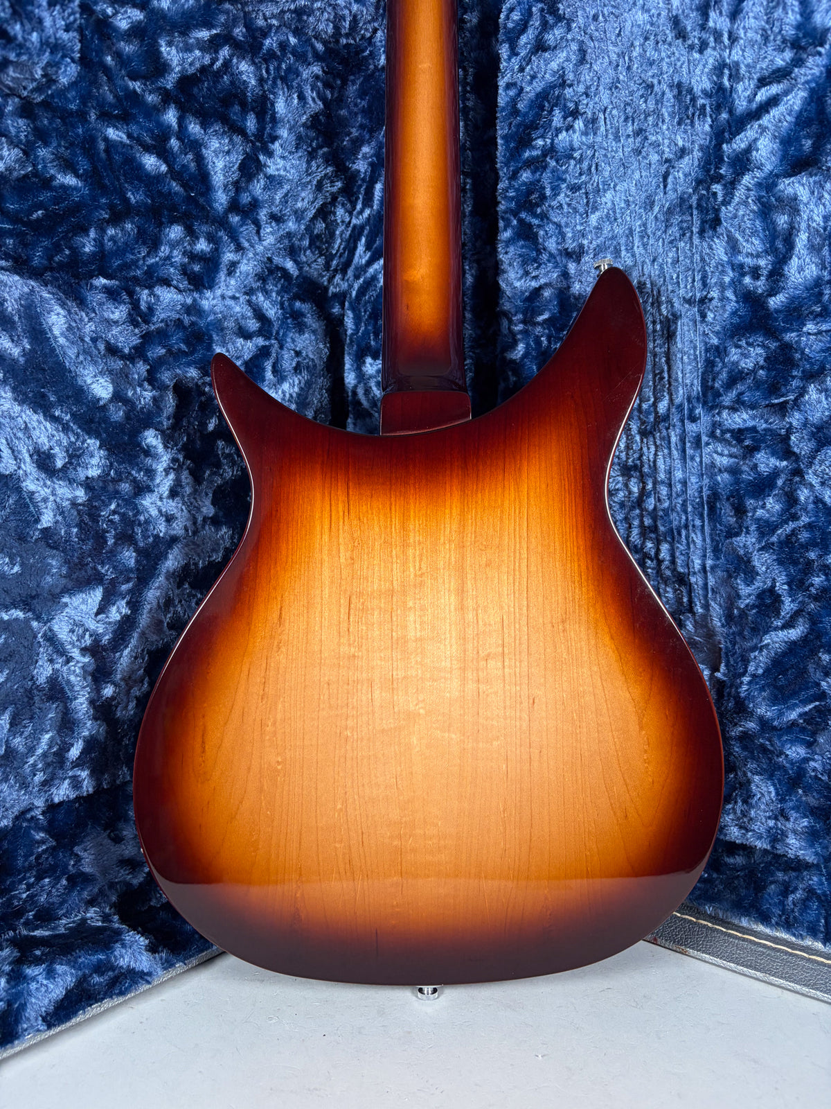The guitar's back, a glossy Montezuma Brown sunburst, shows subtle wood grain and a strap button at the bottom.