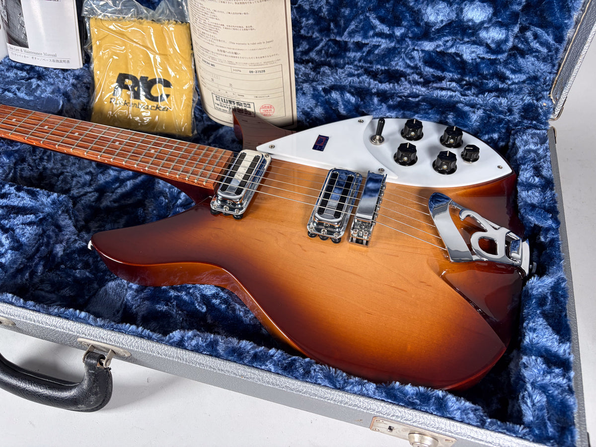 A Montezuma Brown Rickenbacker 310 C64 in its blue plush-lined case, showing the body, controls, and part of the neck.