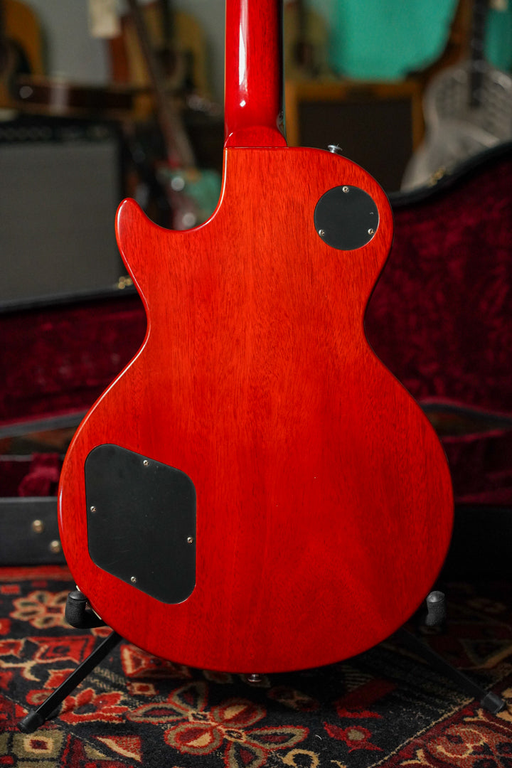 The back of a cherry red electric guitar, showing the neck joint and two black control cavity covers.