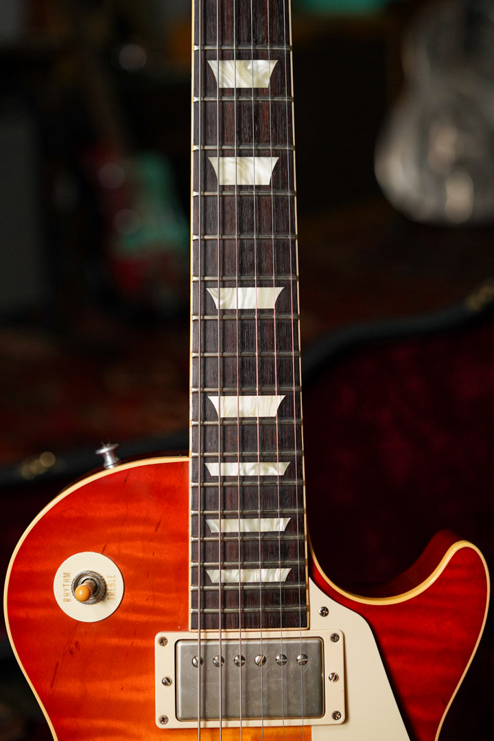 Close-up of the sunburst body and dark fretboard with trapezoid inlays, showing the neck pickup and cream rhythm/treble switch.
