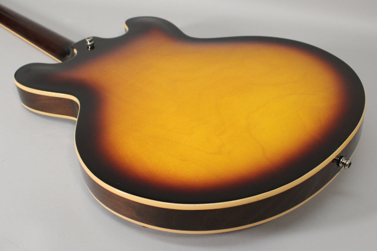 The guitar's sunburst back, with a bright orange-yellow center fading to dark brown, shows light finish checking.