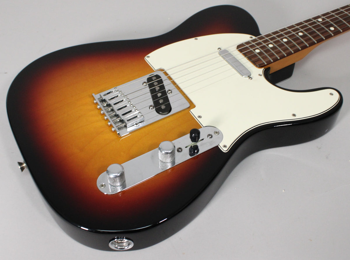 Upper body of a sunburst Telecaster, angled right, showing a cream pickguard, chrome bridge, and control plate with two knurled knobs.