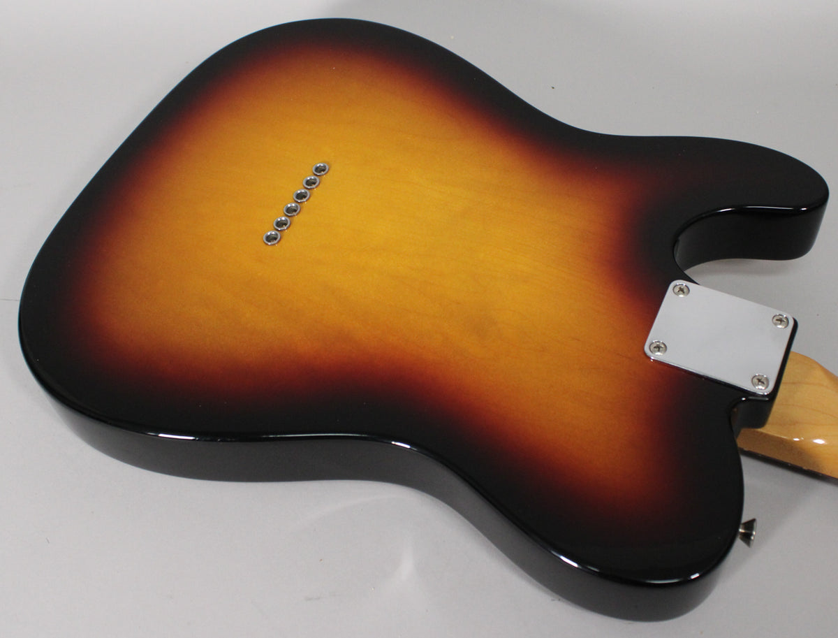 The guitar's sunburst back, with six string-through-body ferrules and a chrome neck plate, shows light wear on the lower bout.