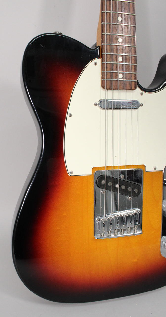 Close-up of a sunburst Telecaster body, showing the lower bout, bridge, neck pickup, and part of the fretboard.