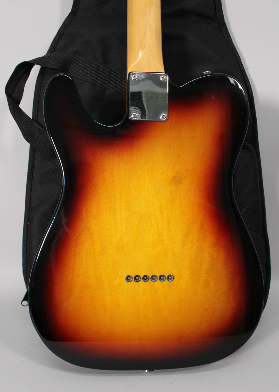 The guitar's sunburst back, with a chrome neck plate and six string ferrules, rests against a black gig bag.
