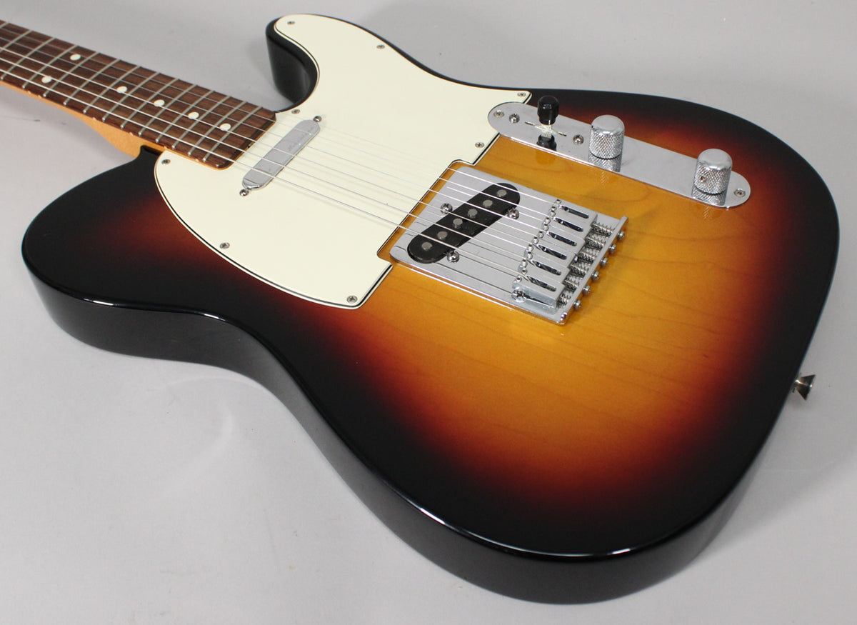 Sunburst Telecaster body, angled from the neck, showing the cream pickguard, chrome bridge, and control plate with knurled knobs.