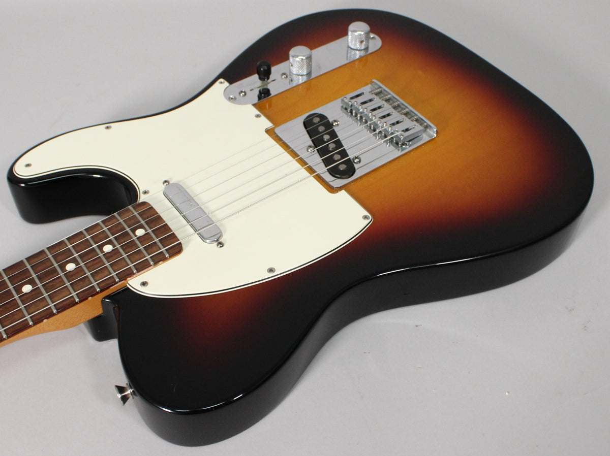 The sunburst Telecaster body is angled from the lower left, showing the white pickguard, chrome bridge, and control plate.